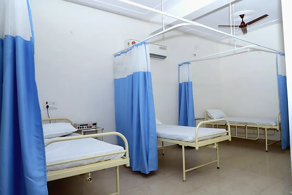 Medical ward with beds and blue privacy curtains